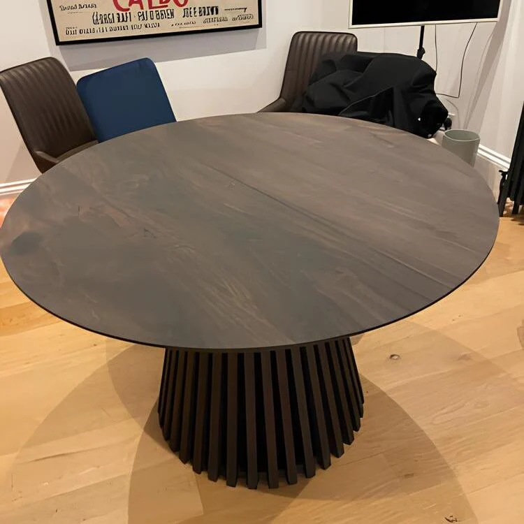 Round Dining Table in Charcoal Walnut - featuring its distinctive faceted pipe leg - is a unique and custom-made masterpiece that melds