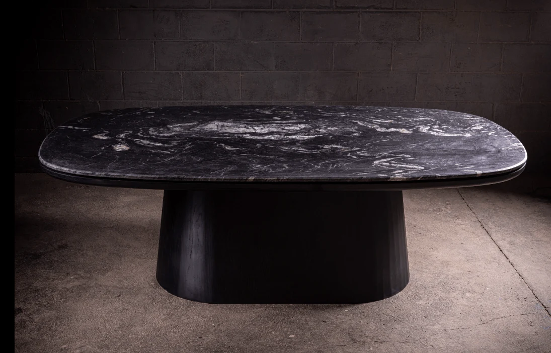 Dining Table - A study in contrast — the leathered quartzite top carries a tactile depth that shifts with the light, anchored by a black matte...