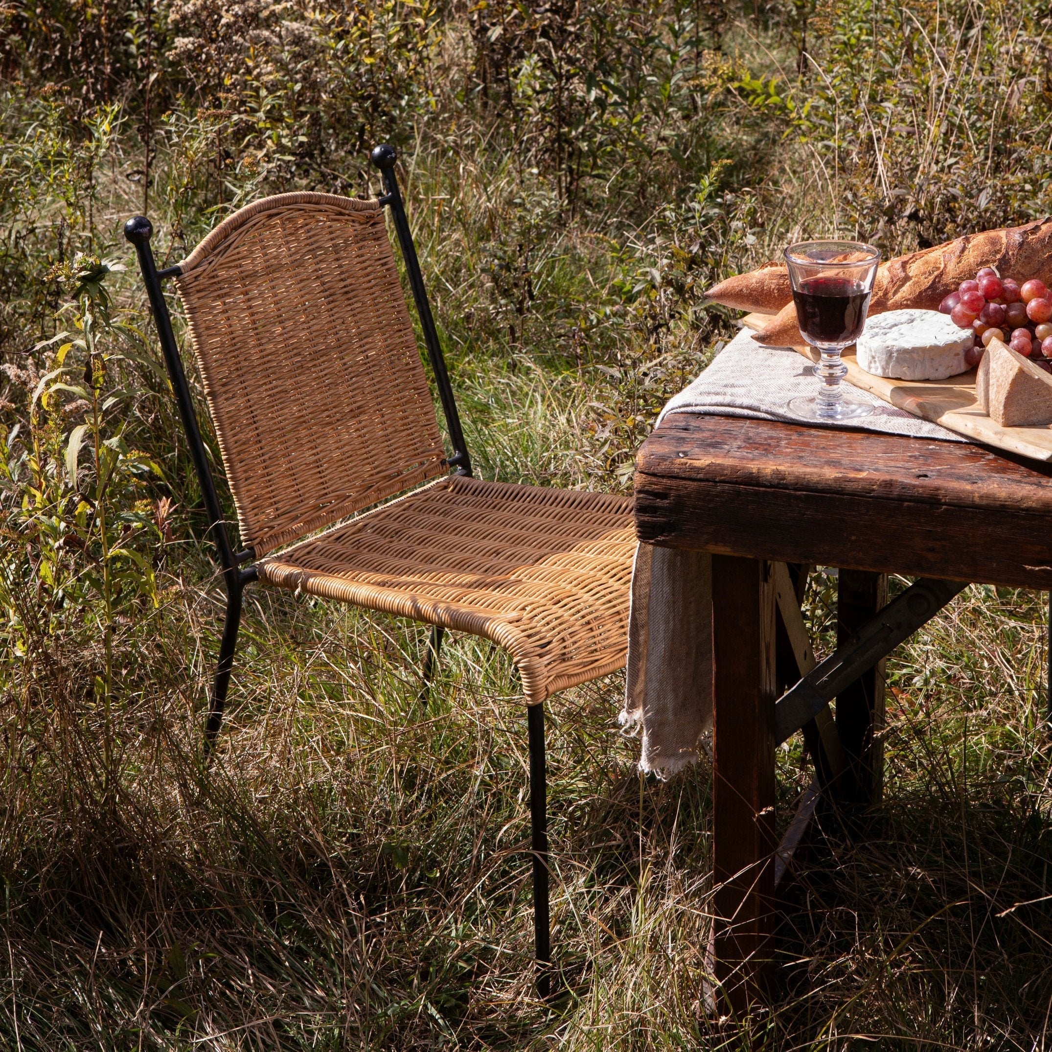 Dining Chair - crafted from sustainably sourced rattan and hand hammered wrought iron, this vintage inspired, stackable dining chair easily...